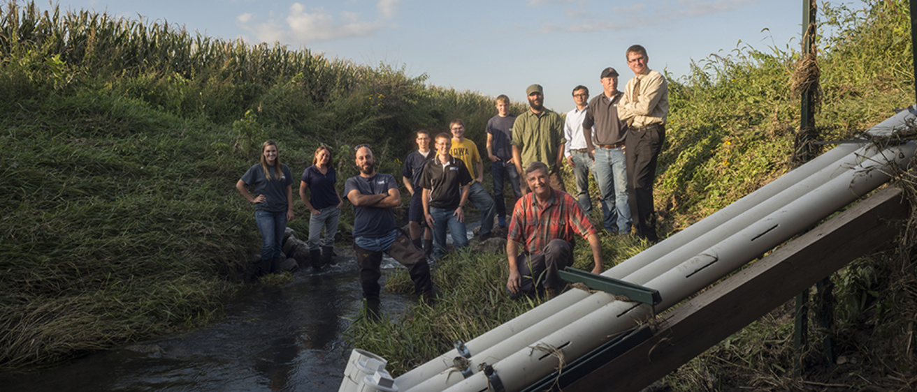 A group of people pose near a water-quality sensor in Clear Creek